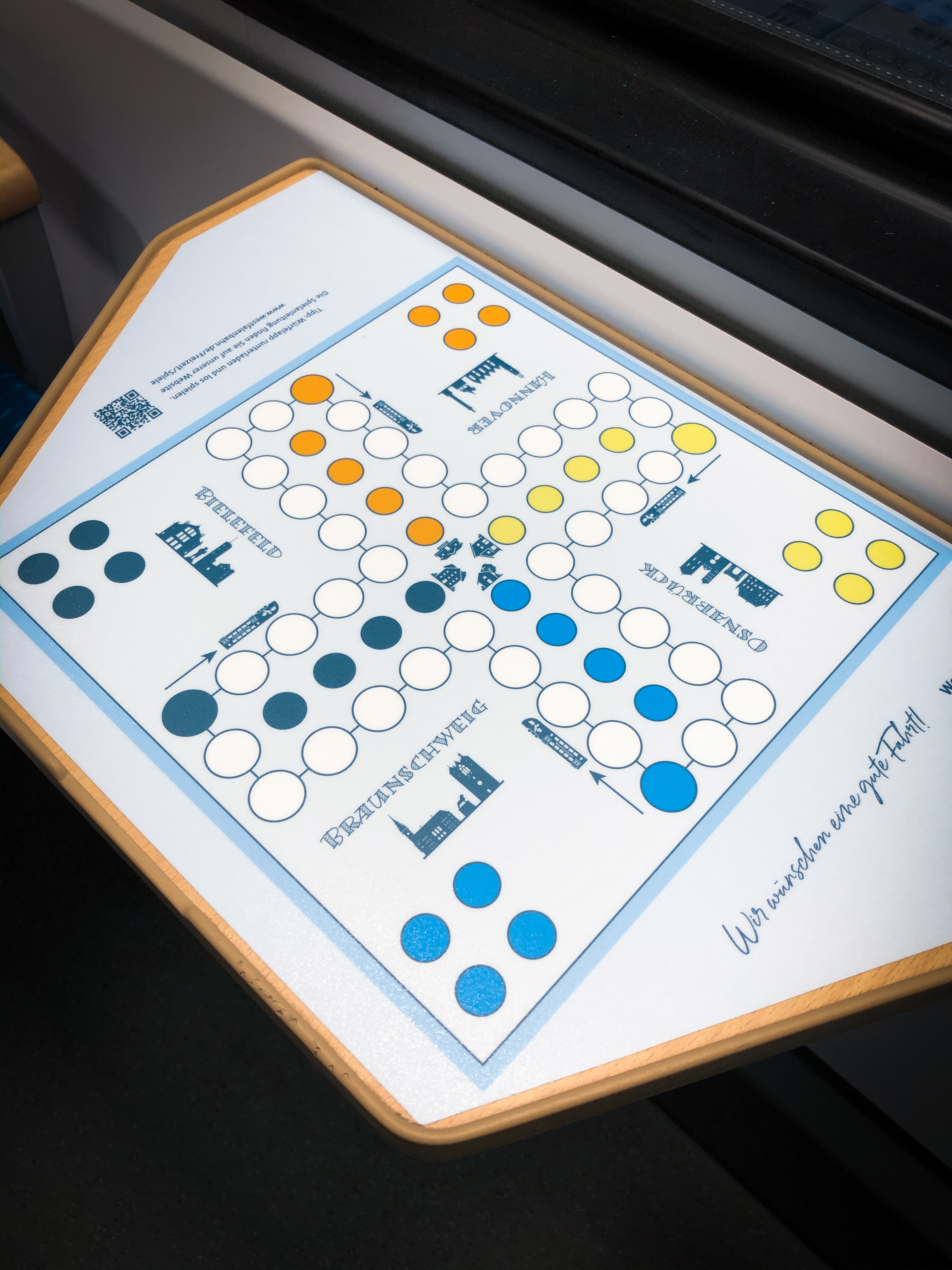 Das Brettspiel "Mensch-Ärgere-Dich-Nicht" auf einem Zugtisch geklebt.