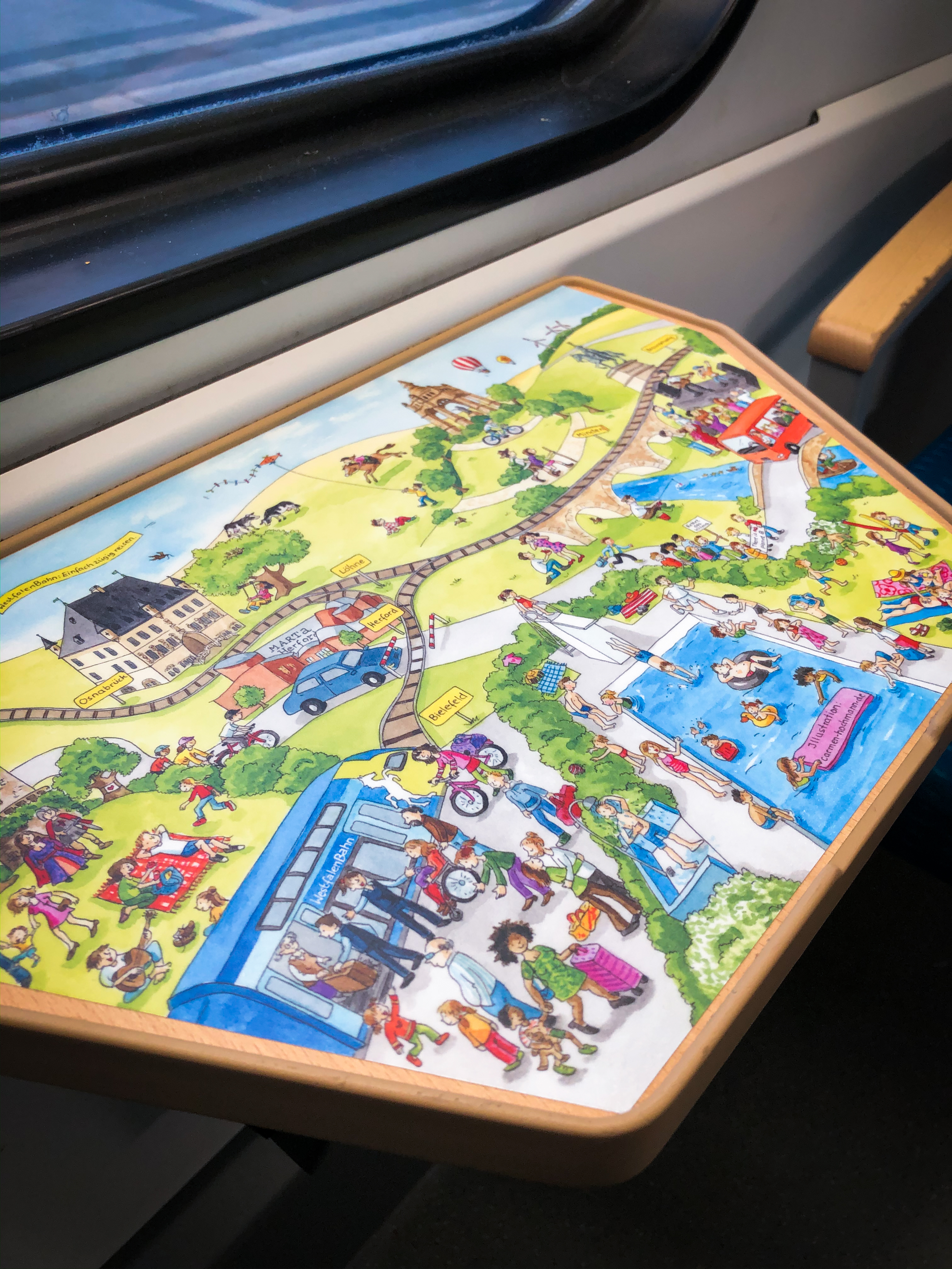 Das Brettspiel "Bahnreise" auf einen Zugtisch geklebt.